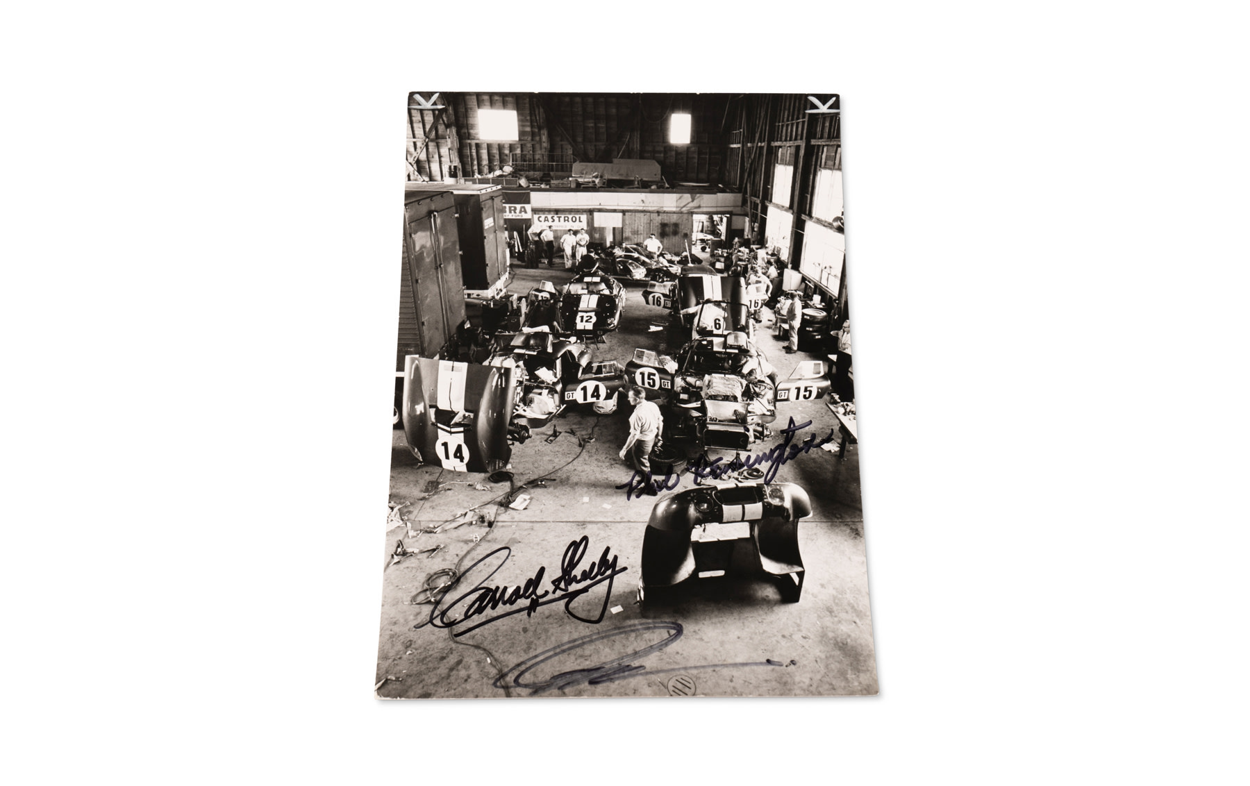 Photograph of the Shelby American Garage at Sebring, Signed by Carroll Shelby, Peter Brock, and Phil Remington